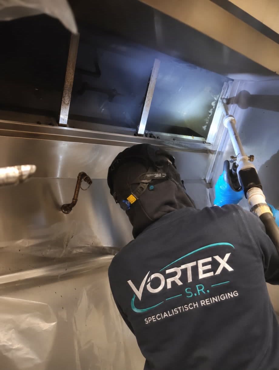 Vortex S.R. medewerker reinigt een horeca-afzuigkap met een spuitlans