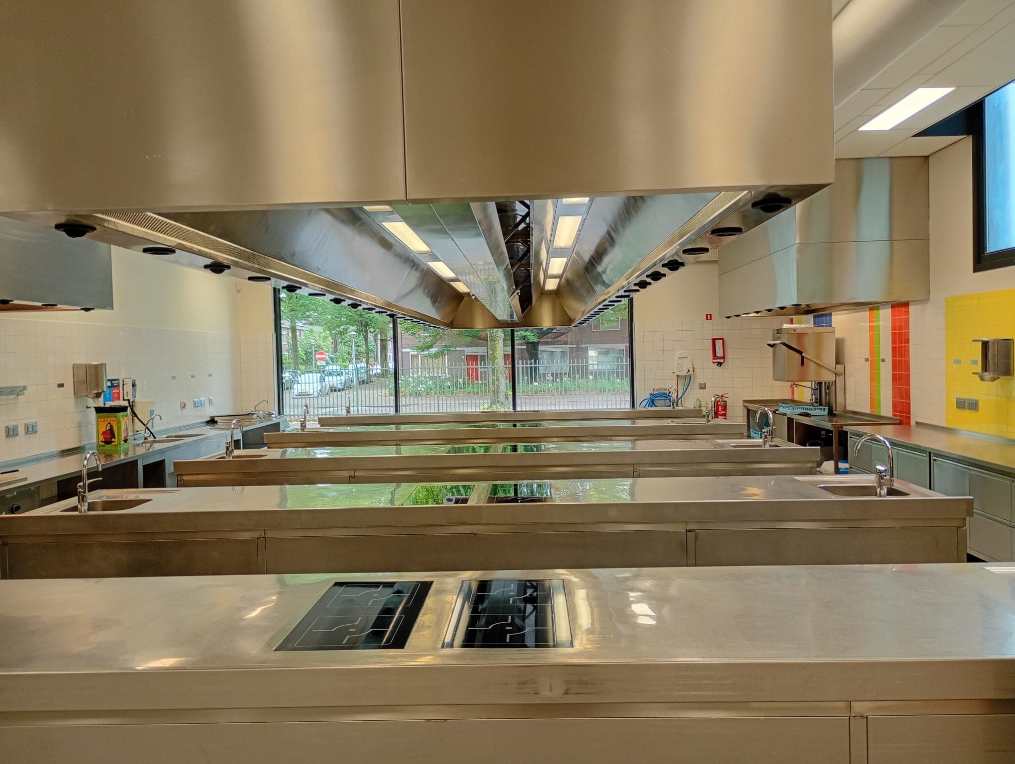 Grootkeuken met schone RVS afzuigkappen en kookeilanden na reiniging door Vortex S.R.
