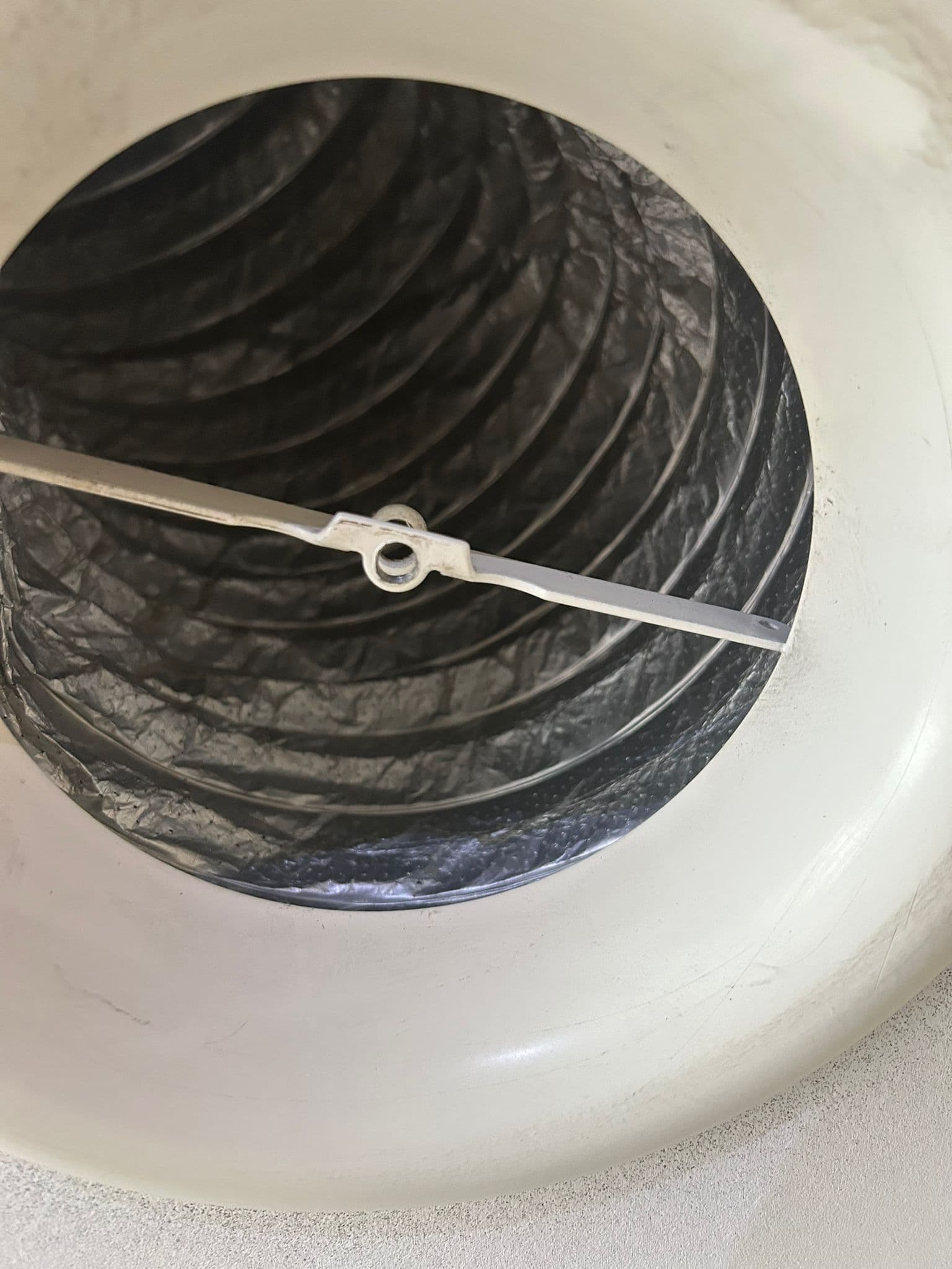 Schoon ventilatiekanaal achter wit plafondventiel na reiniging